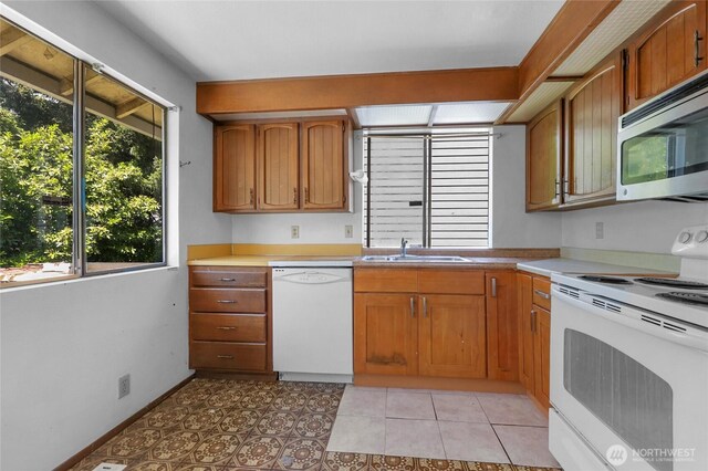7407 25th Ave NE, Seattle, WA 98115 - kitchen featuring white appliances, a sink, brown cabinetry, and light countertops