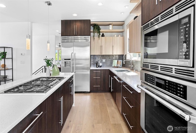 2222 E Mcgraw St, Seattle, WA 98112 - kitchen featuring built in appliances, light wood-type flooring, open shelves, a sink, and dark brown cabinets