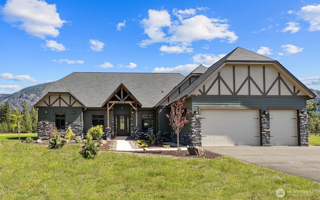 1550 Old Cedars Rd, Cle Elum, WA 98922 - tudor-style house featuring asphalt driveway, an attached garage, a front lawn, stone siding, and a shingled roof