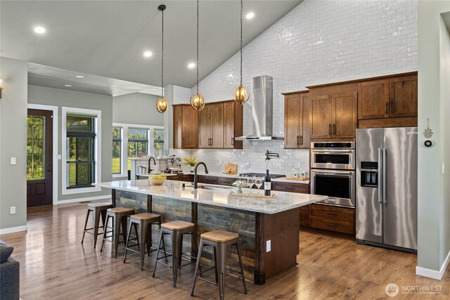 1550 Old Cedars Rd, Cle Elum, WA 98922 - kitchen with stainless steel appliances, wall chimney exhaust hood, high vaulted ceiling, a sink, and an island with sink