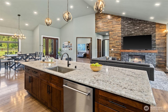 1550 Old Cedars Rd, Cle Elum, WA 98922 - kitchen with a sink, stainless steel dishwasher, a stone fireplace, light stone countertops, and high vaulted ceiling