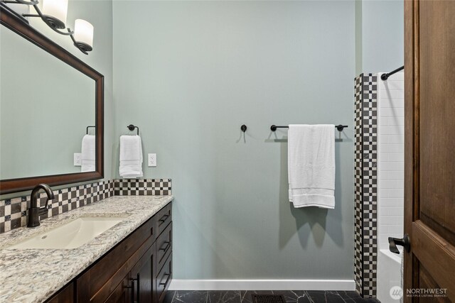 1550 Old Cedars Rd, Cle Elum, WA 98922 - full bath with baseboards, vanity, washtub / shower combination, and tasteful backsplash