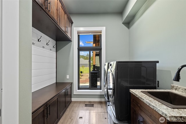 1550 Old Cedars Rd, Cle Elum, WA 98922 - washroom with cabinet space, light wood-style flooring, washer and clothes dryer, and baseboards