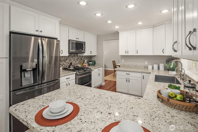 10808 158th Ct NE, Redmond, WA 98052 - kitchen featuring appliances with stainless steel finishes, a sink, white cabinetry, recessed lighting, and decorative backsplash