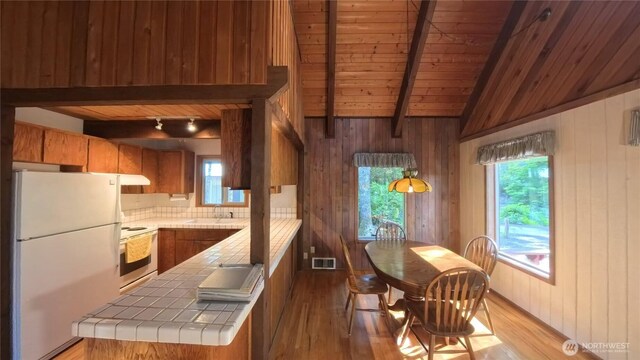 321 N Lake Surf Dr, Lilliwaup, WA 98555 - kitchen with freestanding refrigerator, tile counters, stove, wooden ceiling, and brown cabinets