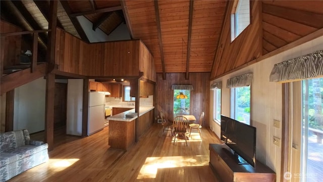 321 N Lake Surf Dr, Lilliwaup, WA 98555 - kitchen featuring brown cabinetry, freestanding refrigerator, high vaulted ceiling, a wood ceiling with exposed beams, and light countertops