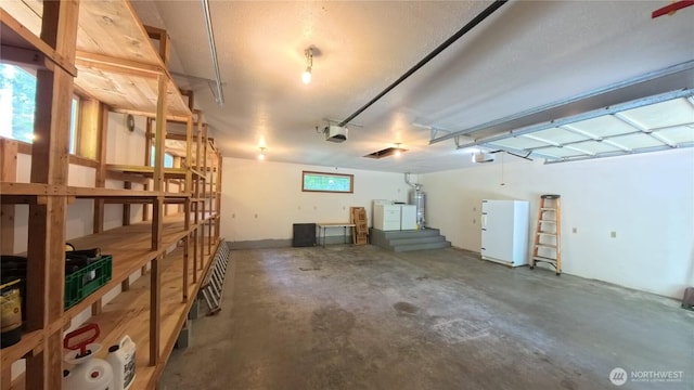 321 N Lake Surf Dr, Lilliwaup, WA 98555 - garage featuring a garage door opener, water heater, washer / dryer, and freestanding refrigerator