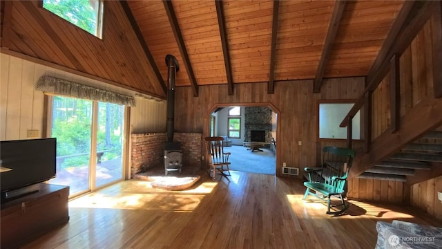 321 N Lake Surf Dr, Lilliwaup, WA 98555 - living room with a wood stove, wood walls, wood finished floors, a wood ceiling with exposed beams, and high vaulted ceiling