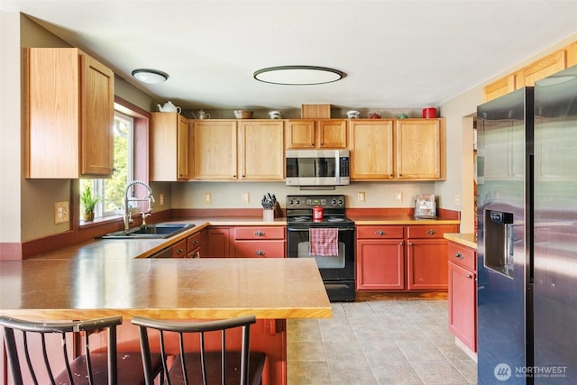 114 Black Bear Ln, Centralia, WA 98531 - kitchen with stainless steel appliances, a sink, a peninsula, a kitchen bar, and light tile patterned flooring