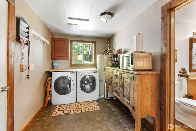 114 Black Bear Ln, Centralia, WA 98531 - washroom with washing machine and dryer, strapped water heater, and dark tile patterned flooring