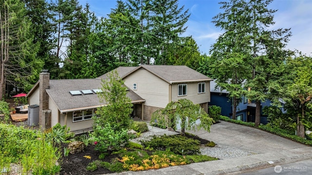 17620 NE 29th St, Redmond, WA 98052 - view of front of house featuring roof mounted solar panels, roof with shingles, a chimney, driveway, and brick siding