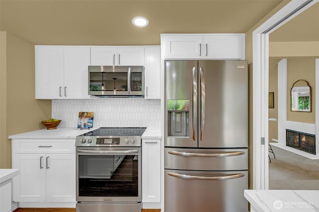 17620 NE 29th St, Redmond, WA 98052 - kitchen featuring stainless steel appliances, white cabinetry, light stone countertops, decorative backsplash, and recessed lighting