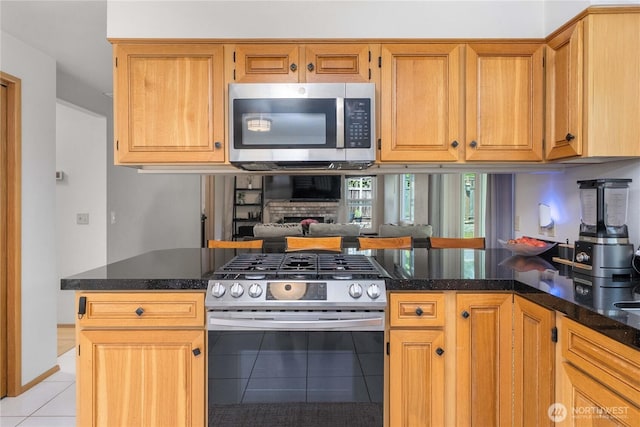 27742 214th Ave SE, Maple Valley, WA 98038 - kitchen with stainless steel appliances, light tile patterned floors, a peninsula, and dark stone counters