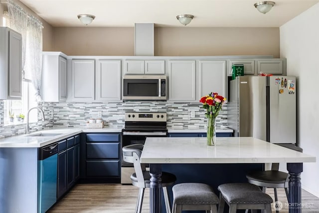 570 Beaver Blvd Unit A, Pacific, WA 98047 - kitchen with appliances with stainless steel finishes, a sink, a breakfast bar area, and backsplash