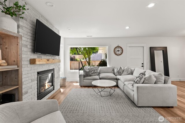 9814 36th St E, Edgewood, WA 98371 - living area featuring a fireplace, light wood-style floors, baseboards, and recessed lighting
