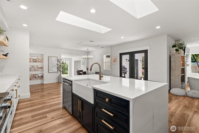 9814 36th St E, Edgewood, WA 98371 - kitchen with a sink, a skylight, stainless steel appliances, dark cabinetry, and recessed lighting