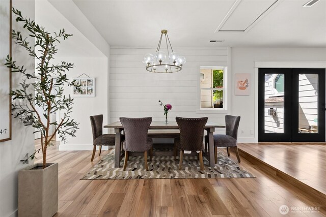 9814 36th St E, Edgewood, WA 98371 - dining space featuring wood finished floors, a chandelier, french doors, baseboards, and attic access