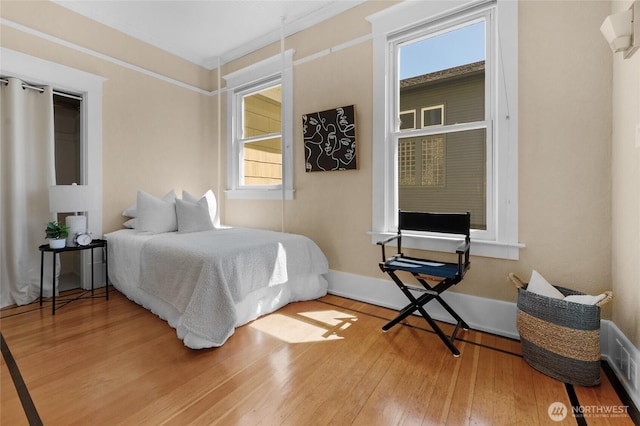 920 4th Ave N, Seattle, WA 98109 - bedroom featuring multiple windows, wood finished floors, baseboards, and ornamental molding