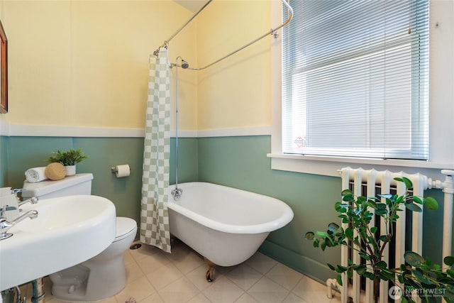 920 4th Ave N, Seattle, WA 98109 - bathroom featuring radiator heating unit, a soaking tub, toilet, a shower with curtain, and baseboards