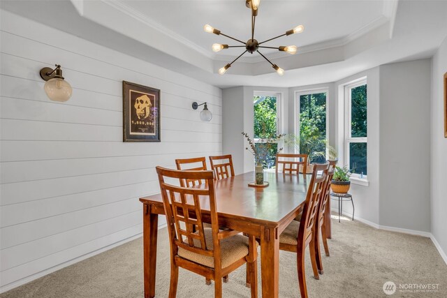 25161 13th Ave S, Des Moines, WA 98198 - dining space featuring a raised ceiling, a chandelier, crown molding, light carpet, and wooden walls
