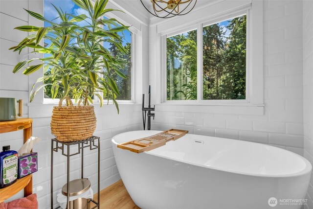 25161 13th Ave S, Des Moines, WA 98198 - bathroom featuring a soaking tub and wood finished floors