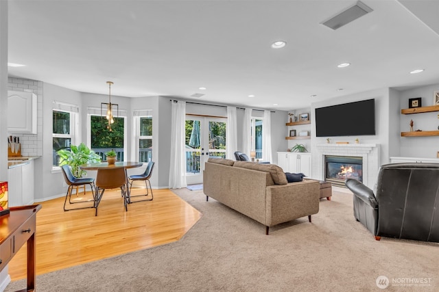 25161 13th Ave S, Des Moines, WA 98198 - living room featuring plenty of natural light, recessed lighting, a glass covered fireplace, light carpet, and light wood-style floors