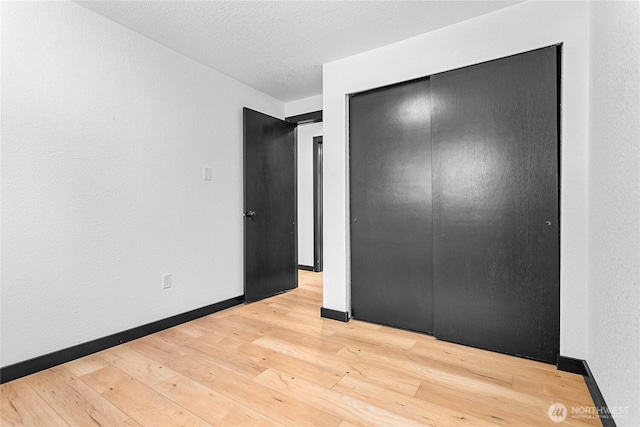 1668 Sapphire Trl, Bellingham, WA 98226 - unfurnished bedroom with light wood-style flooring, a closet, baseboards, and a textured ceiling