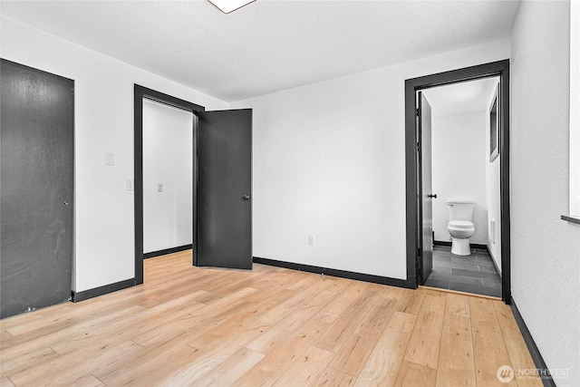 1668 Sapphire Trl, Bellingham, WA 98226 - unfurnished bedroom with light wood-style floors, baseboards, and ensuite bath