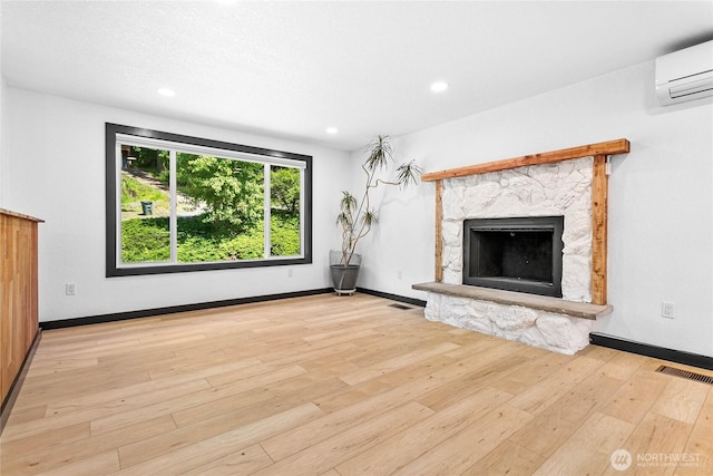 1668 Sapphire Trl, Bellingham, WA 98226 - unfurnished living room featuring an AC wall unit, hardwood / wood-style floors, a fireplace, recessed lighting, and baseboards