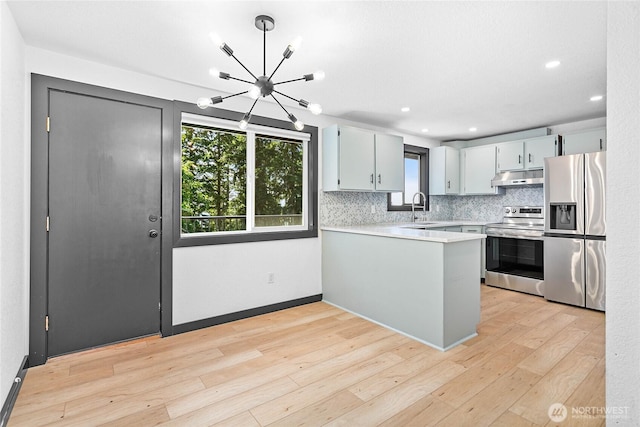 1668 Sapphire Trl, Bellingham, WA 98226 - kitchen with stainless steel appliances, under cabinet range hood, light countertops, plenty of natural light, and recessed lighting