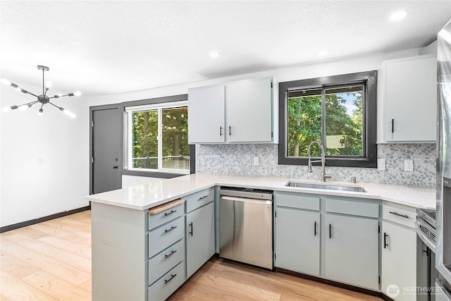 1668 Sapphire Trl, Bellingham, WA 98226 - kitchen featuring appliances with stainless steel finishes, a sink, a peninsula, a chandelier, and decorative backsplash