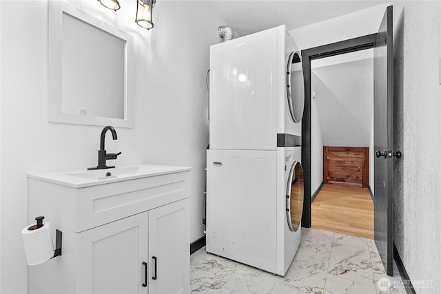 1668 Sapphire Trl, Bellingham, WA 98226 - laundry area featuring estacked washer and dryer, light marble finish flooring, and a sink