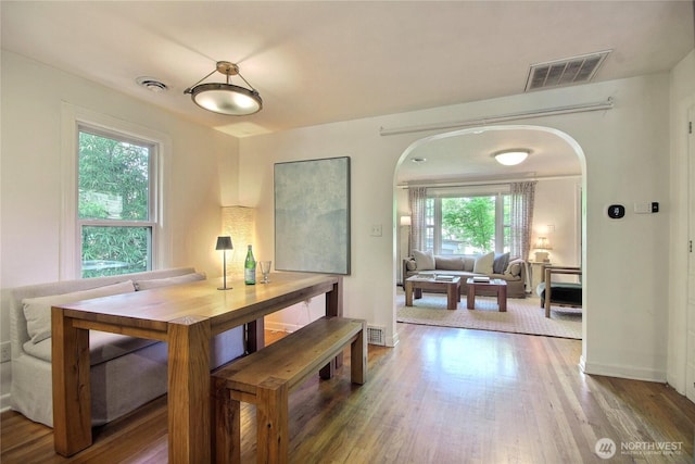 719 N 92nd St, Seattle, WA 98103 - dining area featuring arched walkways, wood finished floors, and baseboards