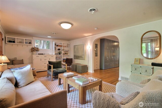 719 N 92nd St, Seattle, WA 98103 - living area with arched walkways, light wood-style floors, and crown molding