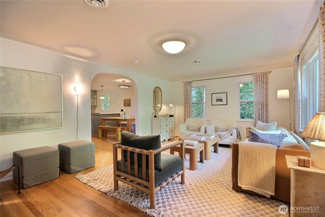 719 N 92nd St, Seattle, WA 98103 - living area featuring arched walkways and light wood finished floors