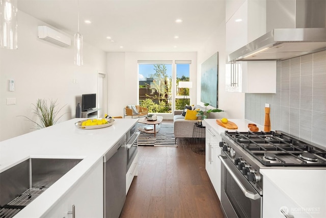 922 N 36th St, Seattle, WA 98103 - kitchen featuring wall chimney exhaust hood, appliances with stainless steel finishes, a wall unit AC, white cabinets, and recessed lighting