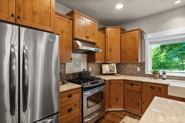 1808 153rd Street Ct NW, Gig Harbor, WA 98332 - kitchen featuring appliances with stainless steel finishes, extractor fan, decorative backsplash, brown cabinetry, and recessed lighting