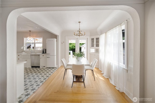 707 Ryan Ave, Sumner, WA 98390 - dining room with a chandelier, arched walkways, and light flooring