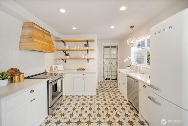 707 Ryan Ave, Sumner, WA 98390 - kitchen featuring appliances with stainless steel finishes, custom range hood, light flooring, white cabinets, and backsplash