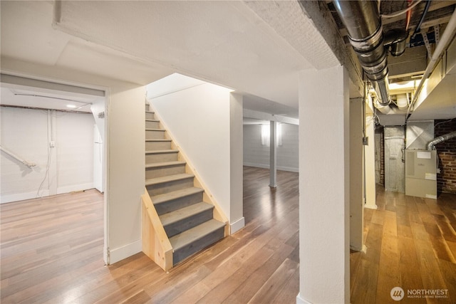 707 Ryan Ave, Sumner, WA 98390 - finished basement featuring stairway, hardwood / wood-style floors, and heating unit