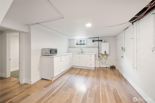 707 Ryan Ave, Sumner, WA 98390 - below grade area featuring tankless water heater, light wood finished floors, and recessed lighting