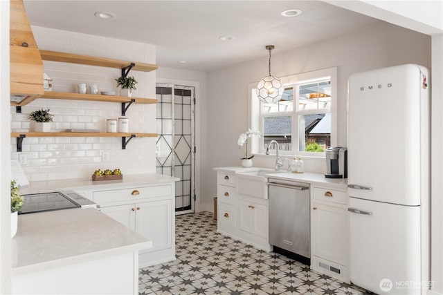707 Ryan Ave, Sumner, WA 98390 - kitchen featuring freestanding refrigerator, stainless steel dishwasher, light flooring, decorative backsplash, and light countertops