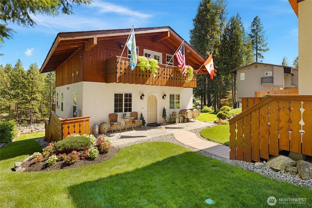 8775 Icicle Rd, Leavenworth, WA 98826 - rear view of house with a lawn, a patio, and a balcony