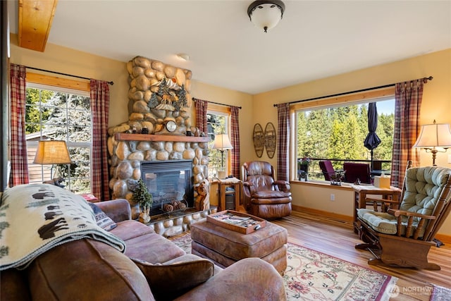 8775 Icicle Rd, Leavenworth, WA 98826 - living room featuring wood finished floors, a fireplace, baseboards, and an office area