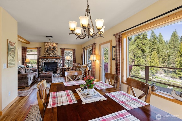 8775 Icicle Rd, Leavenworth, WA 98826 - dining space with a chandelier, a fireplace, wood finished floors, and baseboards