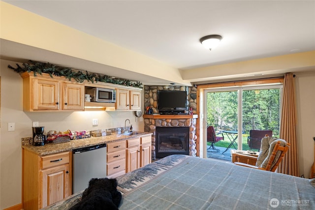 8775 Icicle Rd, Leavenworth, WA 98826 - kitchen with light brown cabinets, stainless steel appliances, a sink, light stone counters, and a fireplace