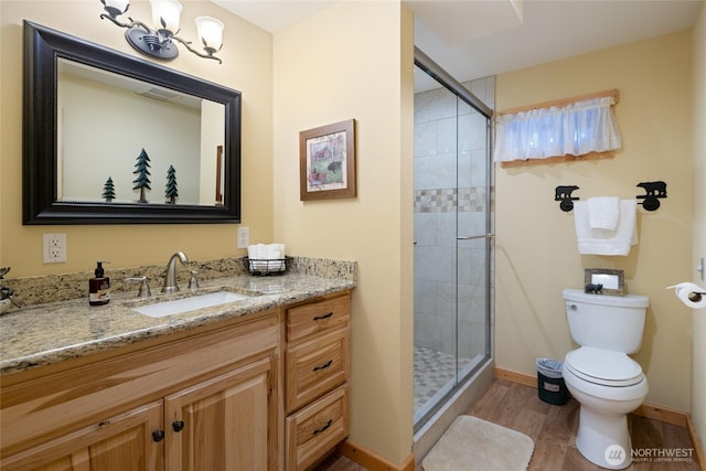 8775 Icicle Rd, Leavenworth, WA 98826 - bathroom with wood finished floors, vanity, toilet, a shower stall, and baseboards