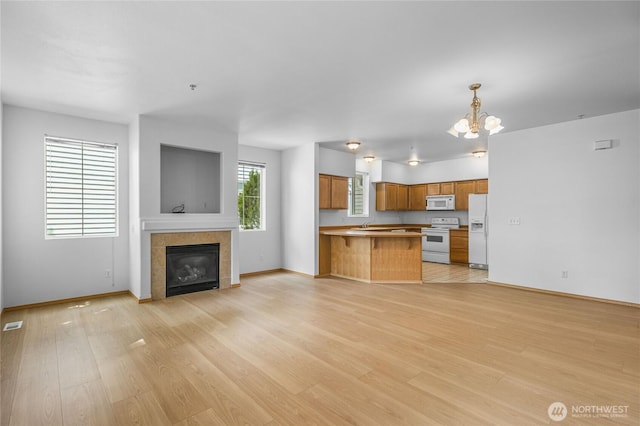 2546 Mitchell Ave Unit 2, Dupont, WA 98327 - unfurnished living room featuring light wood-type flooring, a chandelier, and a tile fireplace