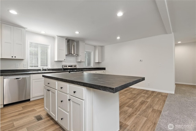 17101 Snowbell Ct SE, Yelm, WA 98597 - kitchen featuring stainless steel appliances, wall chimney range hood, dark countertops, a center island, and a sink