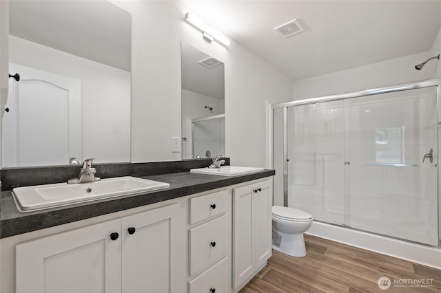 17101 Snowbell Ct SE, Yelm, WA 98597 - bathroom with a shower stall, toilet, double vanity, and wood finished floors